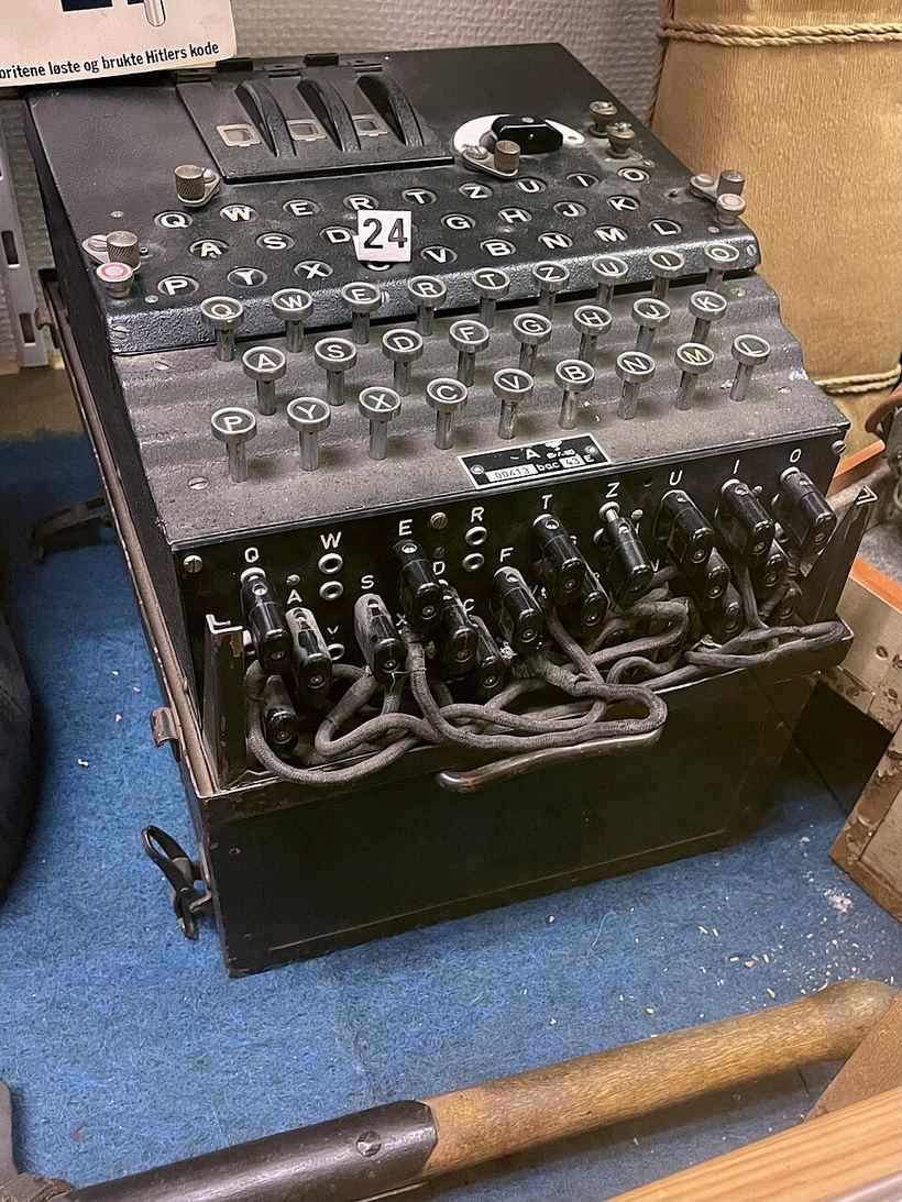 Press a key, current runs through the plugboard, three rotors and a reflector, and lights one lamp.